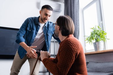 Gülümseyen İspanyol adam evde babamla el sıkışıyor.