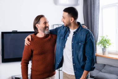 Mutlu ırklar arası baba-oğul kucaklaşmaları ve birbirlerine bakmaları.