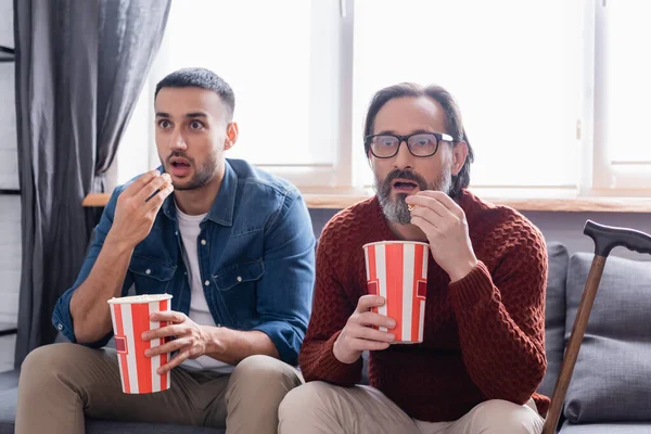 Amazed Interracial Father Son Eating Popcorn While Watching Home — Stock Photo, Image