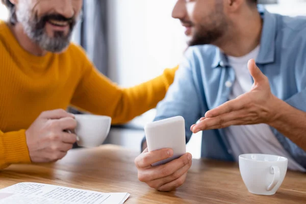 Vista Recortada Joven Apuntando Teléfono Inteligente Cerca Padre Sonriente Cocina — Foto de Stock