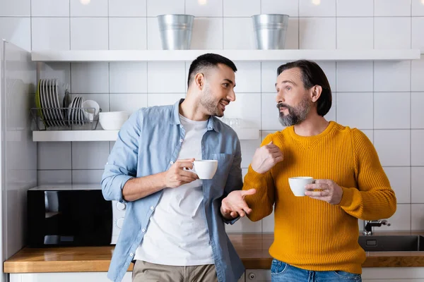 Interracial Father Son Holding Coffee Cups Gesturing While Talking Kitchen — Stock Photo, Image