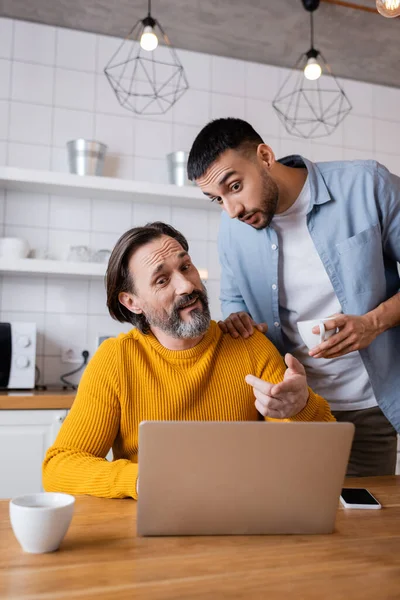 Amazed Man Pointing Laptop Hispanic Son Kitchen — Stock Photo, Image