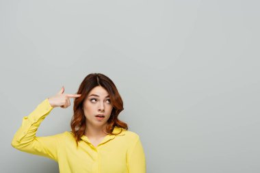 Gri 'ye bakarken aptal hareketler yapan hoşnutsuz bir kadın.