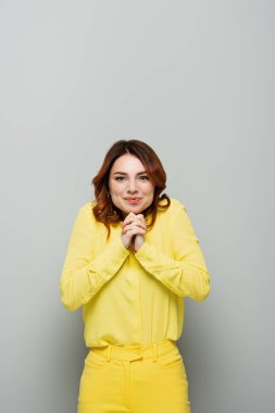 Neşeli kadın kameraya gülümserken yüzünü griye yakın tutarken.