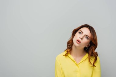 Sarı bluzlu hayretler içinde bir kadın. Gri üzerine inzivaya çekilmiş.