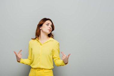arrogant woman pointing with fingers at herself while looking away on grey clipart