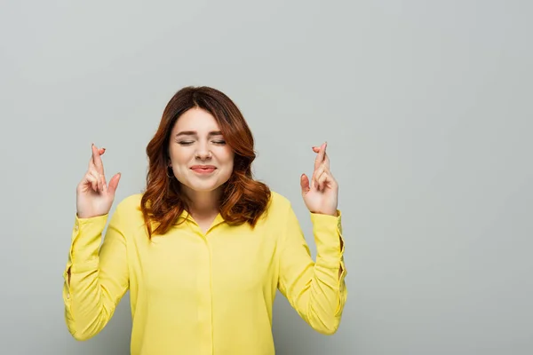 Positive Woman Holding Crossed Fingers While Standing Closed Eyes Grey — Stock Photo, Image