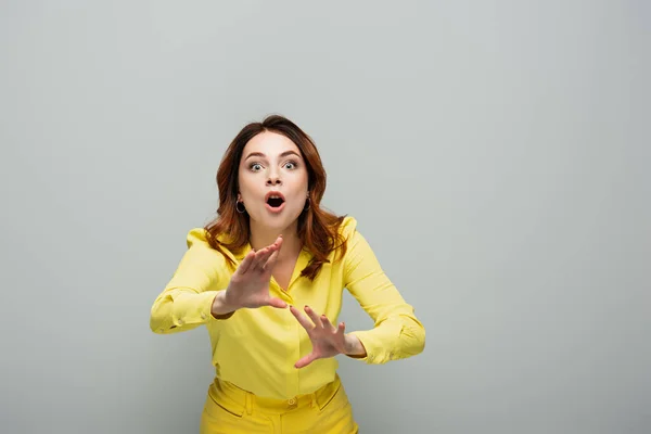 Mujer Sorprendida Camisa Amarilla Haciendo Gestos Mientras Mira Cámara Gris —  Fotos de Stock