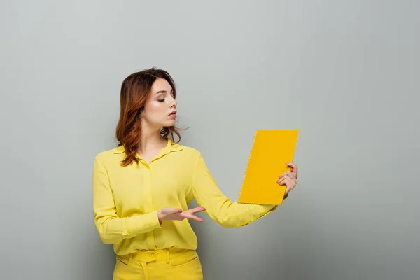 Arrogante Vrouw Gele Blouse Wijzend Naar Notebook Grijs — Stockfoto