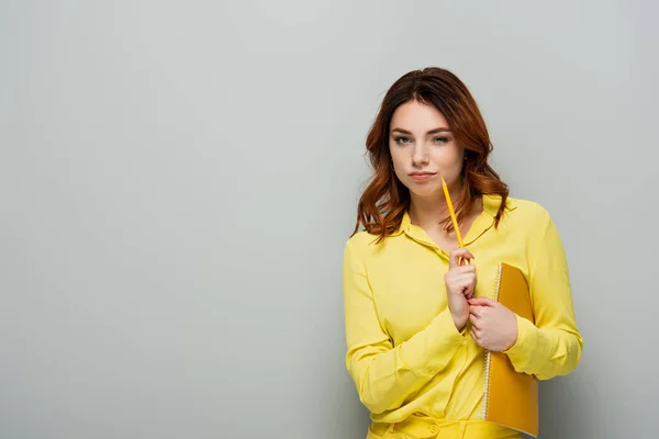 Doordachte Vrouw Met Potlood Notitieboekje Kijkend Naar Camera Grijs — Stockfoto