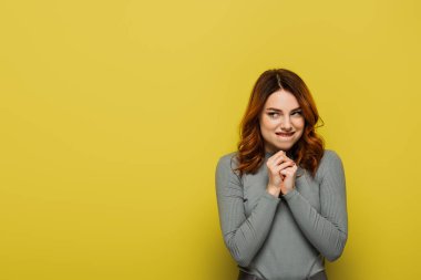 Kıvırcık saçlı sinsi kadın sarıya bakıyor.