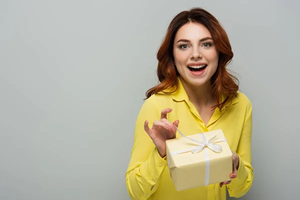 Donna Allegra Guardando Fotocamera Mentre Apriva Scatola Regalo Sul Grigio — Foto Stock