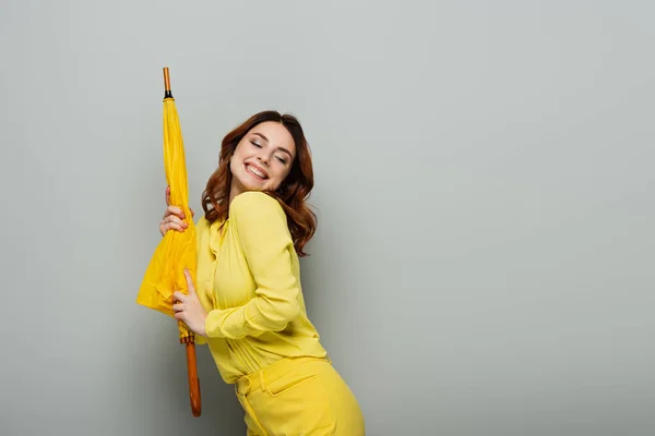 Joyful Woman Holding Yellow Umbrella While Standing Closed Eyes Grey — Stock Photo, Image