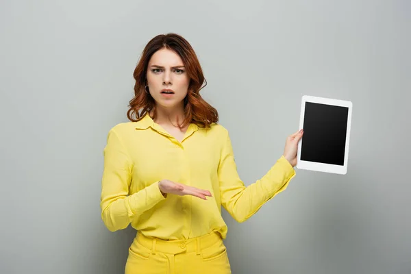 Розчарована Жінка Вказує Цифровий Планшет Порожнім Екраном Сірому — стокове фото