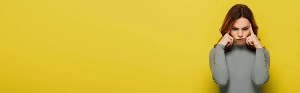 Przemyślana Kobieta Szarym Pulowerze Dotykająca Głowy Żółtym Sztandar — Zdjęcie stockowe