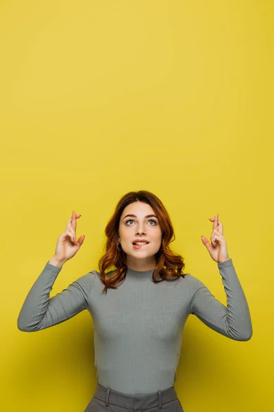 Pełna Nadziei Kobieta Trzymająca Kciuki Patrząc Górę Żółty — Zdjęcie stockowe
