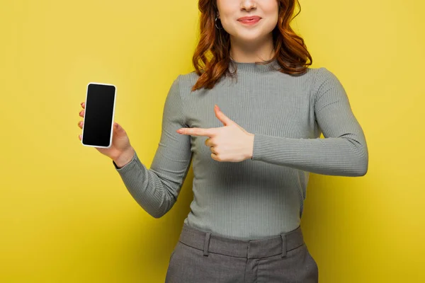 노란색 스크린이 스마트폰을 손가락으로 가리키는 곱슬머리의 여성의 — 스톡 사진
