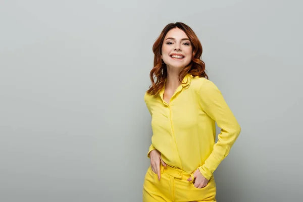 Young Curly Woman Yellow Shirt Standing Hands Pockets Grey — Stock Photo, Image