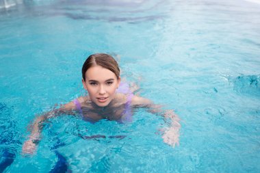 young woman swimming in water of hot spring pool clipart