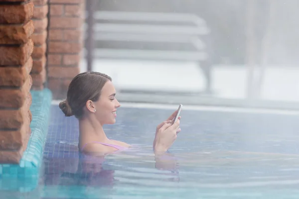 Vista Lateral Mulher Feliz Usando Smartphone Enquanto Toma Banho Piscina — Fotografia de Stock