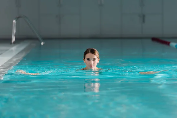 Mujer Joven Mirando Cámara Mientras Nada Piscina Del Centro Spa —  Fotos de Stock