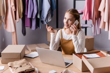 Dizüstü bilgisayar ve paketlerin yakınındaki akıllı telefon siparişini kabul eden pozitif sergi sahibi