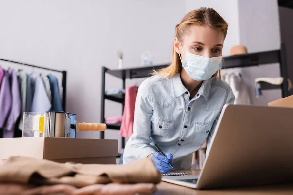 Young Showroom Owner Medical Mask Working Laptop Blurred Foreground — Stock Photo, Image