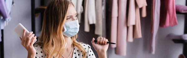 Thoughtful Businesswoman Medical Mask Looking Away While Holding Smartphone Banner — Stock Photo, Image