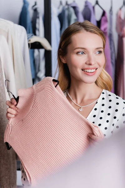 Happy Showroom Owner Holding Knitted Vest While Looking Away Blurred — Stock Photo, Image