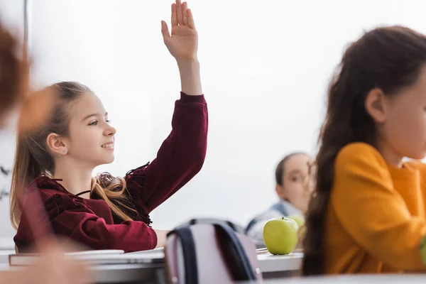 Smiling Schoolkid Raising Hand Apple Book Classroom — Stock Photo, Image