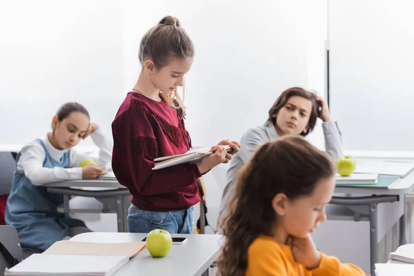 Livro Leitura Aluno Perto Maçã Smartphone Colegas Classe Fundo Embaçado — Fotografia de Stock