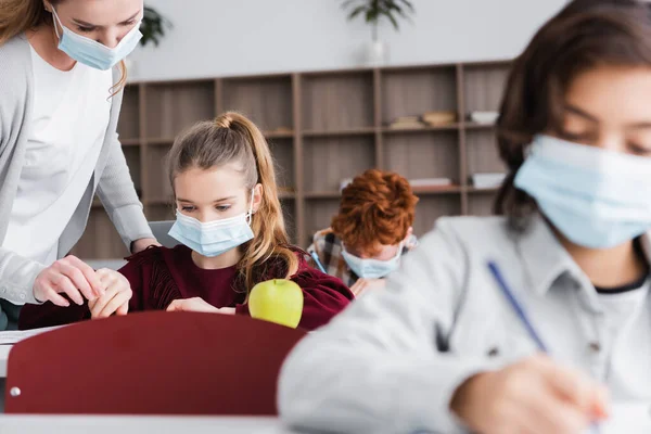 Maestro Máscara Médica Ayudar Colegiala Durante Lección Borrosa Primer Plano — Foto de Stock