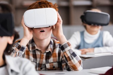 Seçici odak noktası şaşkın okul çocuğu oyun sınıfında vr kulaklık.