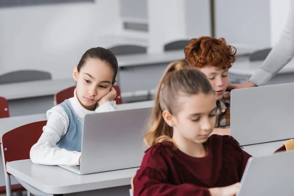 Bored Schoolgirl Sitting Laptop Lesson Classmates Blurred Foreground — Stock Photo, Image