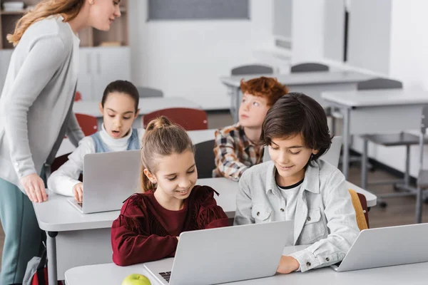 Nauczyciel Stojący Pobliżu Uczniów Pracujących Laptopach Klasie — Zdjęcie stockowe