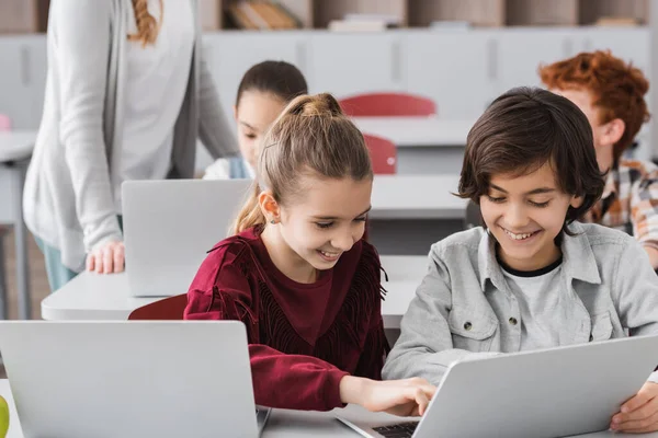 Cheerful Classmates Typing Laptop Pupils Teacher Blurred Background — Stock Photo, Image