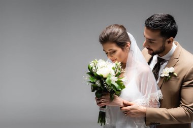Gelin, Arap damadın yanındaki düğün buketini kokluyor. 
