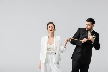 Neşeli gelin, korkmuş Arap damadın yakınındaki kameraya bakıyor. Gri boynu düğümlenmiş. 