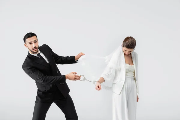 Muslim Groom Pulling Handcuffs Veil Sad Bride Isolated Grey — Stock Photo, Image