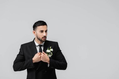 Gri ceketli Arap damat gözlerini kaçırıyor. 