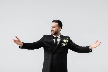 Gri üzerine izole edilmiş şık takım elbiseli neşeli Arap damat. 