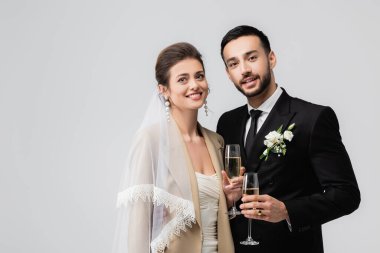 Mutlu Arap damat, gri yolda gelinin yanında şampanya tutuyor. 