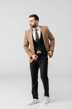 Takım elbiseli ve gri ayakkabılı modaya uygun Arap bir adam.