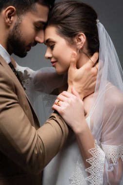 Mutlu, ırklar arası yeni evli çift. Gri renkli gözlerle yüz yüze duruyorlar.