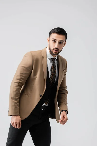 young muslim man in elegant clothes looking at camera isolated on grey