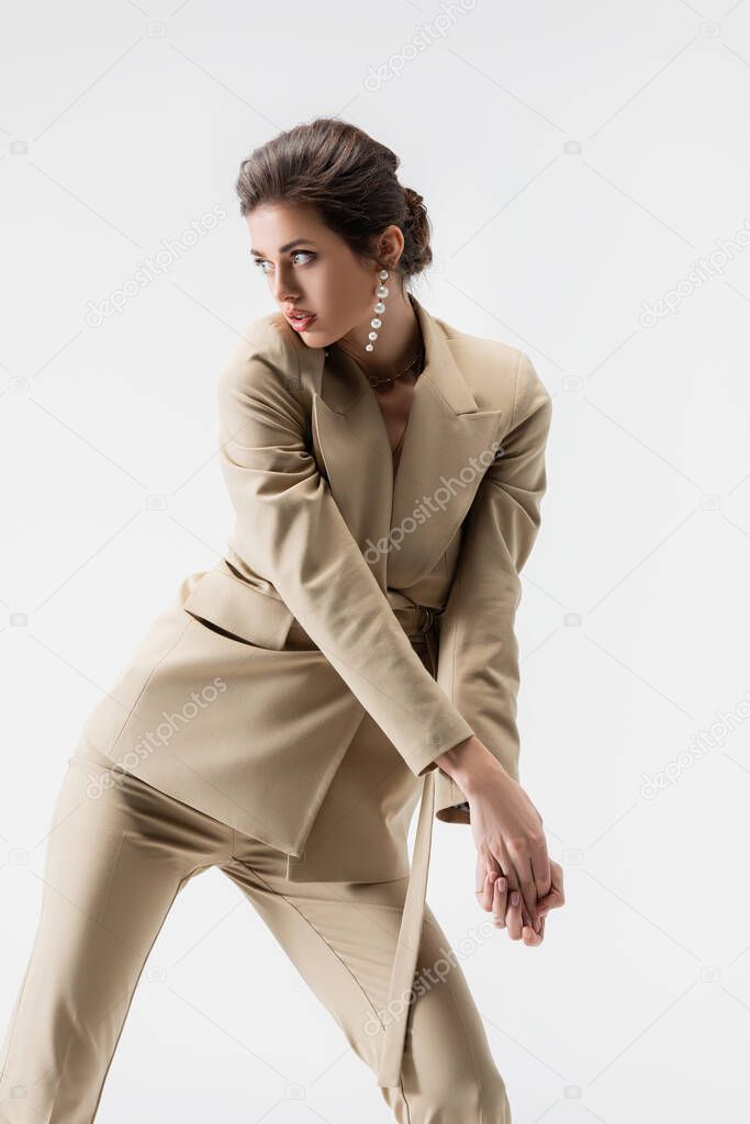 sensual woman looking away while posing isolated on grey