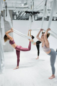 Mladé ženy cvičení ve skupině s houpací sítě během létat jóga  