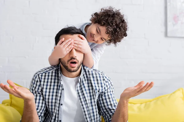 Alegre Chico Musulmán Cubriendo Los Ojos Padre Mostrando Gesto Encogiéndose —  Fotos de Stock