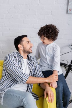 Mutlu Arap baba ve oğul evde konuşurken birbirlerine bakıyorlar.