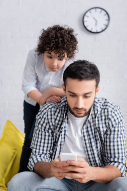 Arabistanlı çocuk cep telefonundan baba mesajlarına bakıyor.